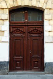 Entrance of house with beautiful wooden door and transom window