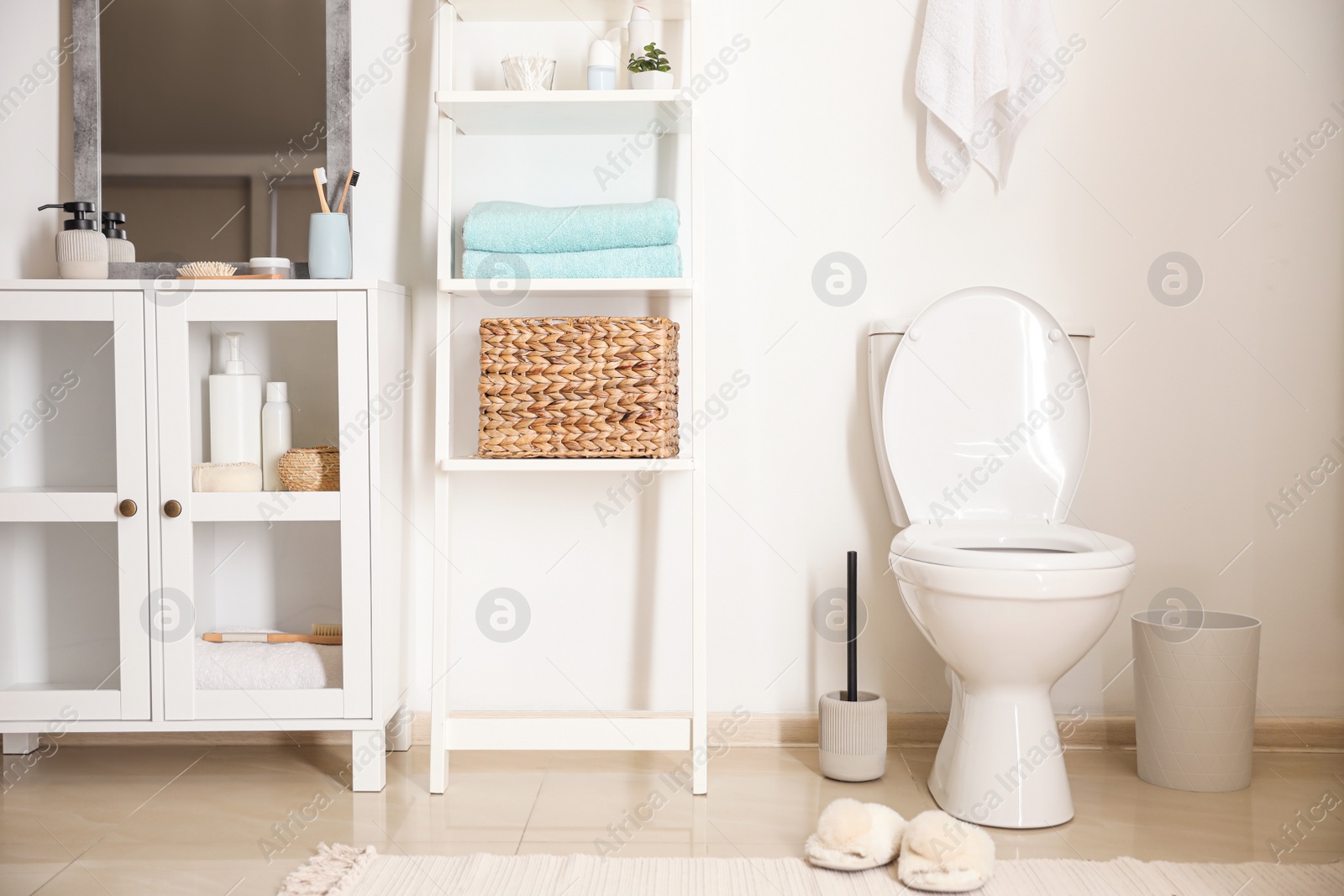 Photo of Modern toilet bowl near white wall in bathroom