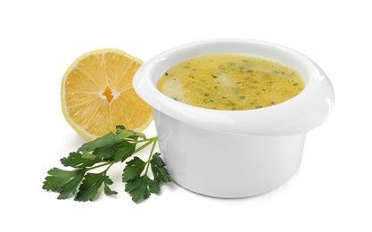 Photo of Bowl with lemon sauce and ingredients on white background. Delicious salad dressing