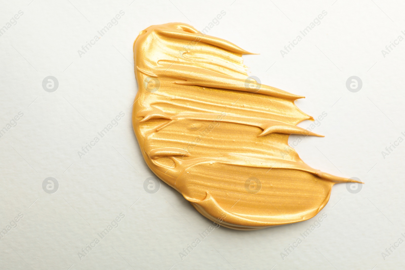 Photo of Golden paint brush strokes on white background