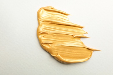 Photo of Golden paint brush strokes on white background