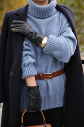Young woman in stylish black leather gloves outdoors, closeup