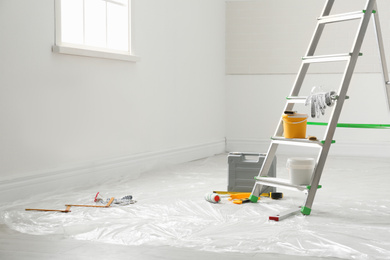Photo of Stepladder and different tools in room. Interior renovation