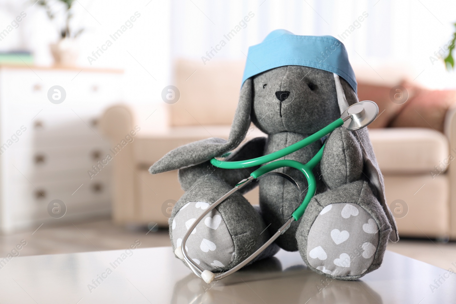 Photo of Stuffed bunny on table in child hospital. Space for text