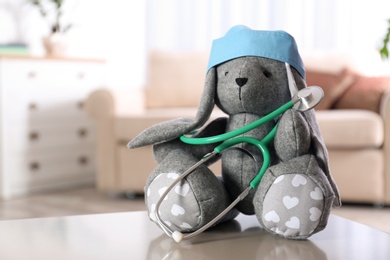 Photo of Stuffed bunny on table in child hospital. Space for text