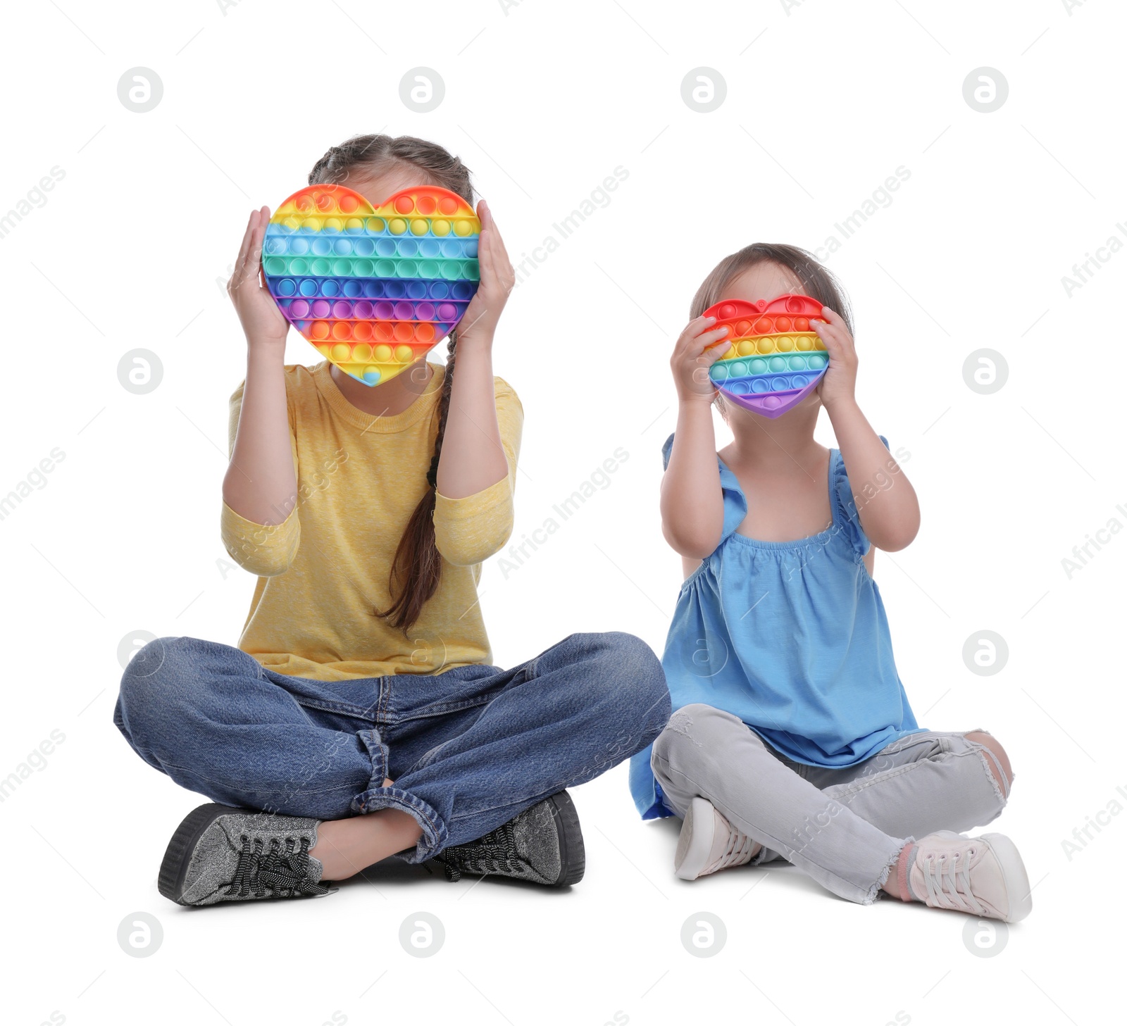 Photo of Little girls with pop it fidget toys on white background