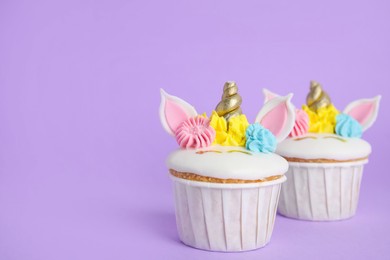 Cute sweet unicorn cupcakes on violet background. Space for text