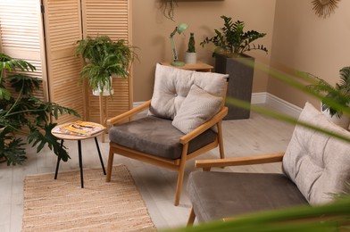 Lounge area interior with comfortable armchairs and beautiful houseplants