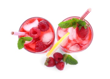 Different delicious lemonades made with soda water and ingredients on white background, top view