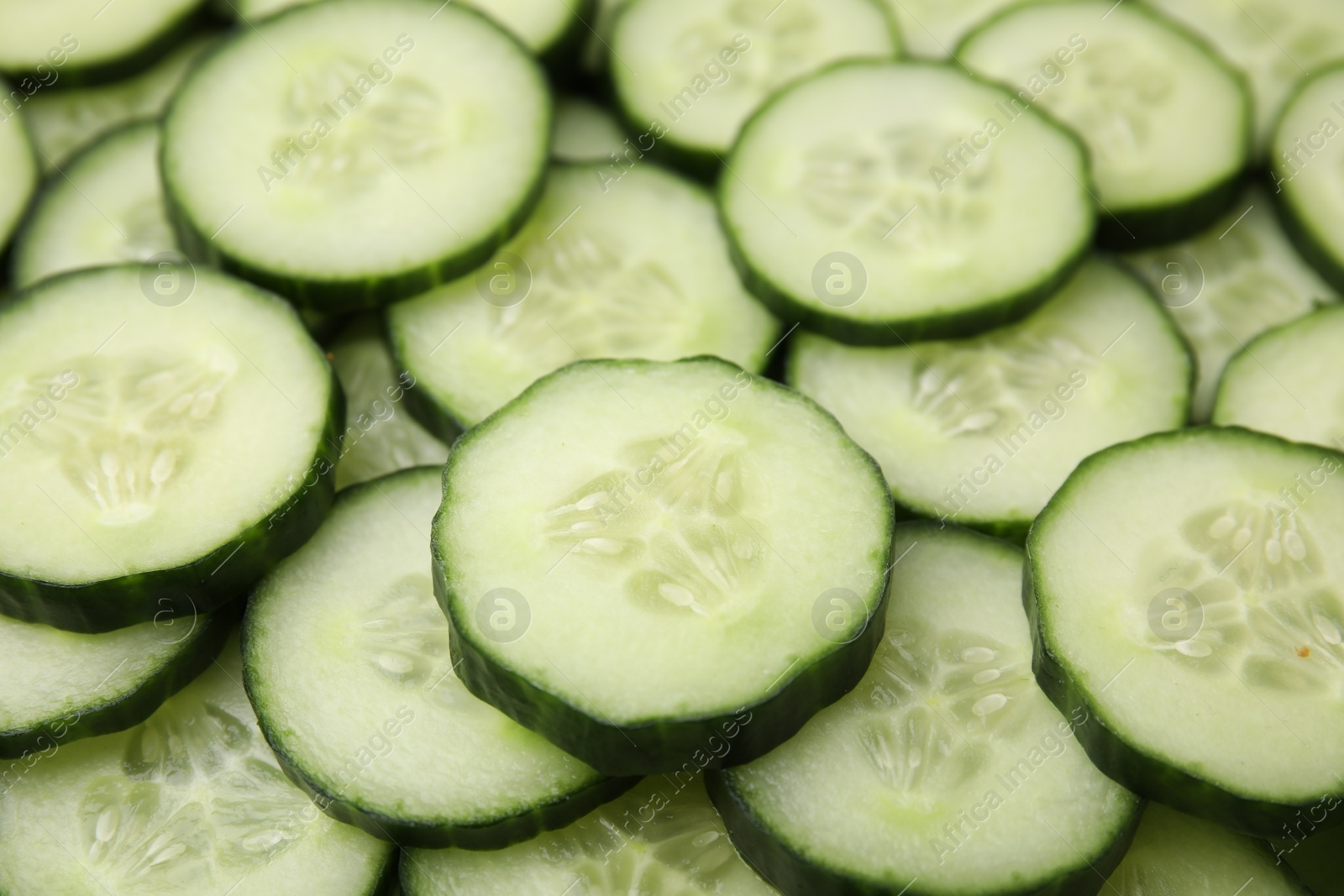 Photo of Fresh slices of cucumbers as background, closeup