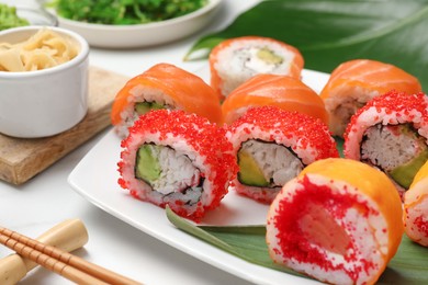 Photo of Different delicious sushi rolls on white table, closeup