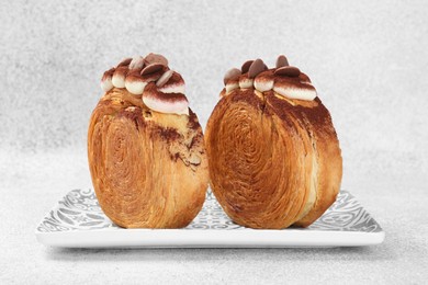 Photo of Supreme croissants with chocolate chips and cream on grey background, closeup. Tasty puff pastry