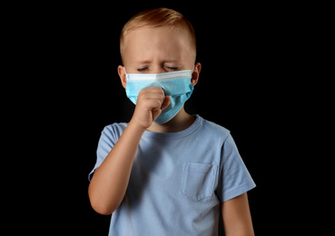 Little boy in medical mask on black background. Virus protection