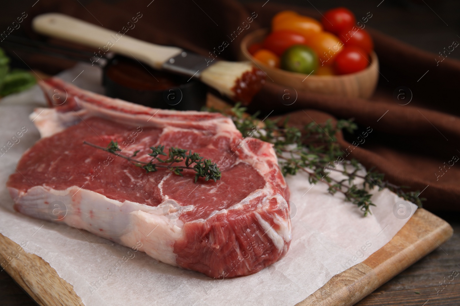 Photo of Raw meat and thyme on wooden table, closeup