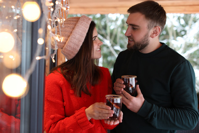 Lovely couple with tasty mulled wine in cafe. Winter vacation