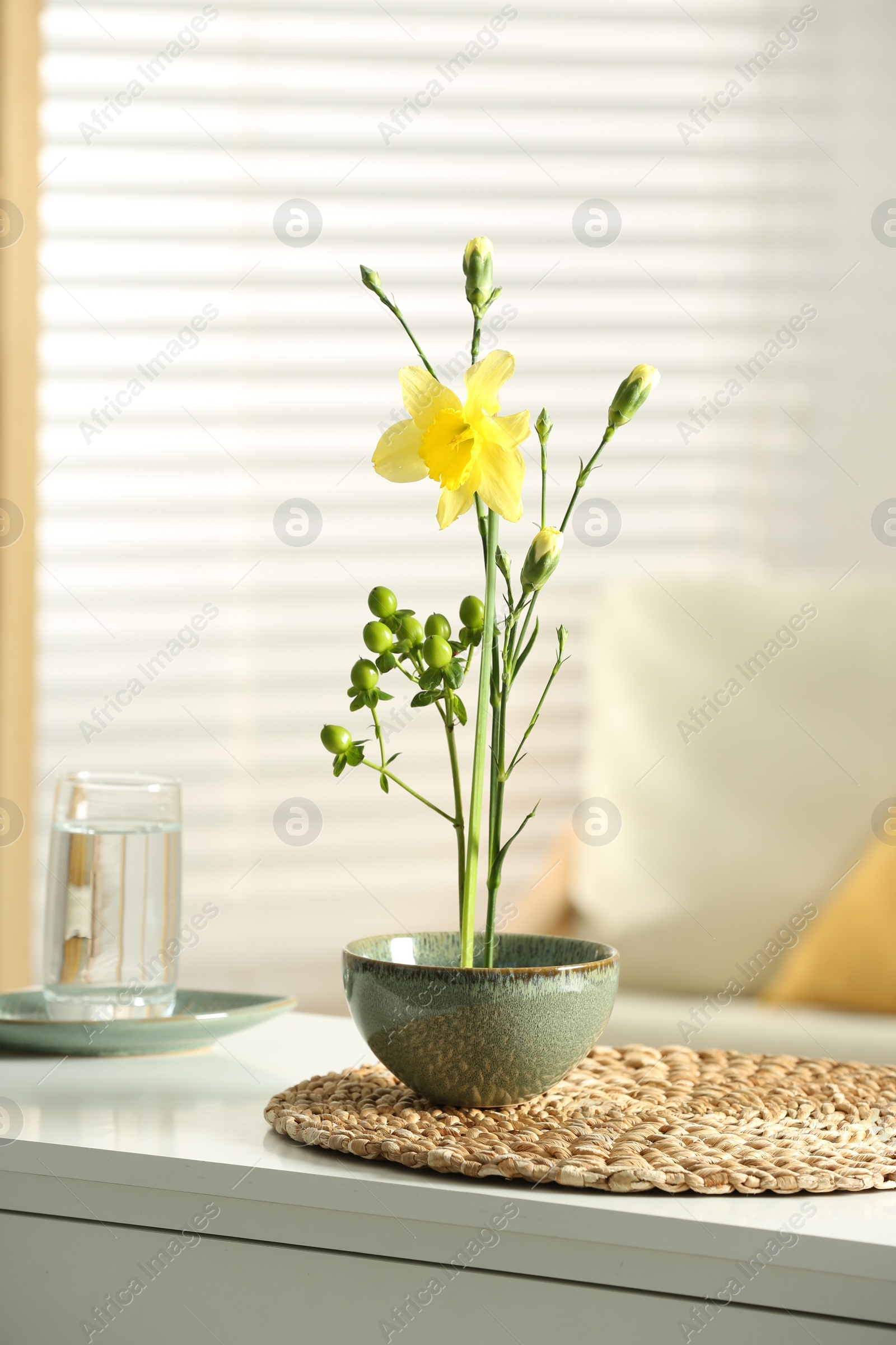 Photo of Stylish ikebana with beautiful yellow narcissus flower carrying cozy atmosphere at home