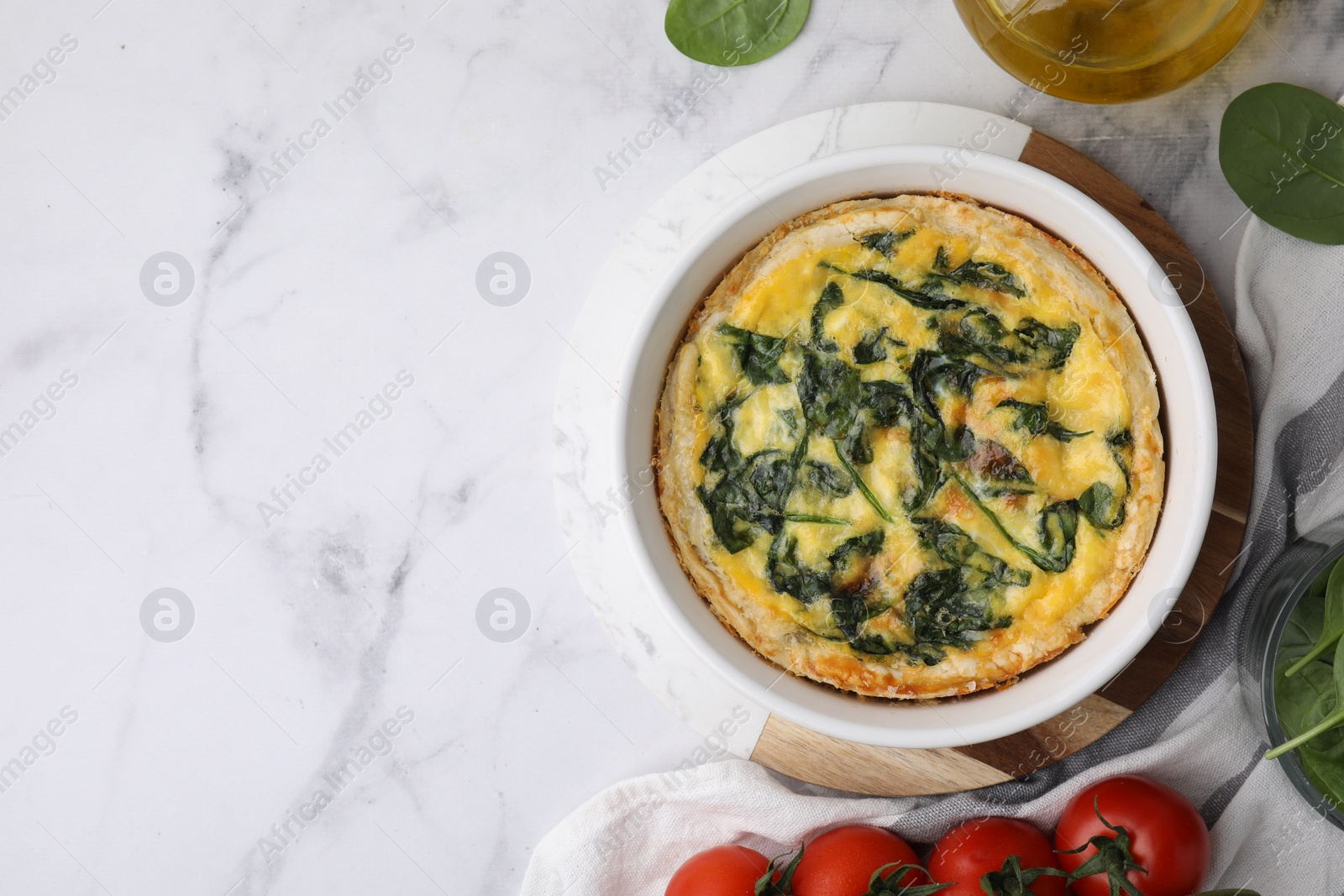 Photo of Delicious pie with spinach on white marble table, flat lay. Space for text