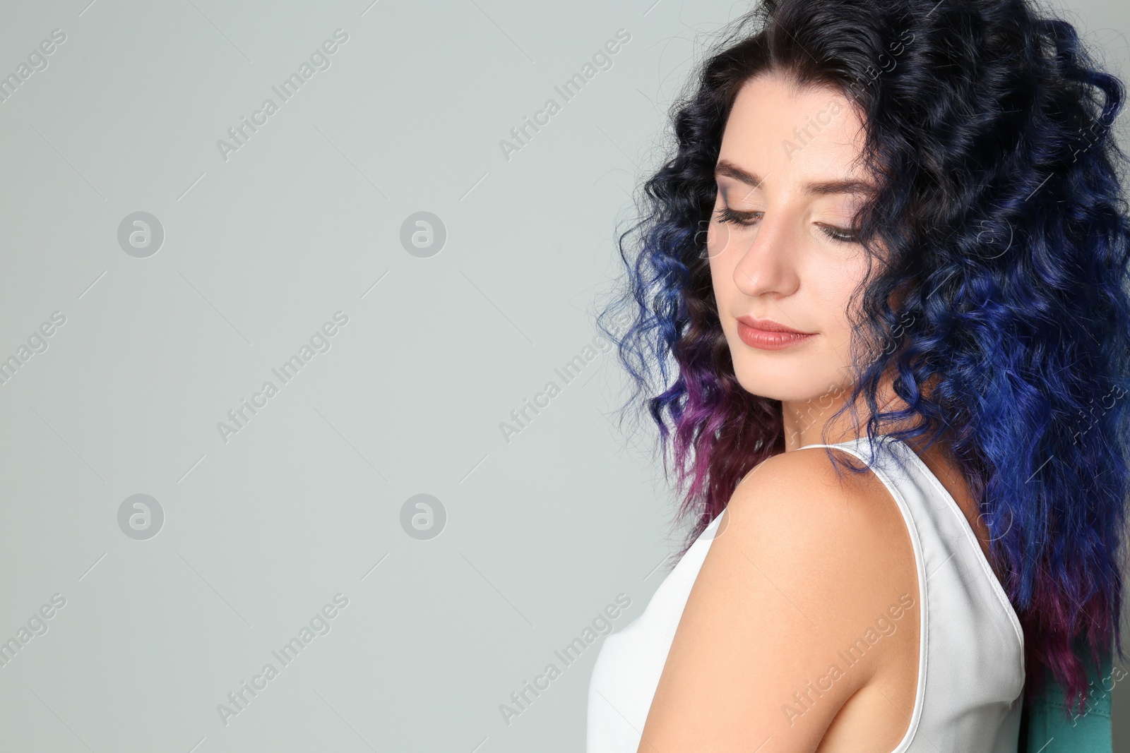 Photo of Young woman with bright dyed hair on light background, space for text