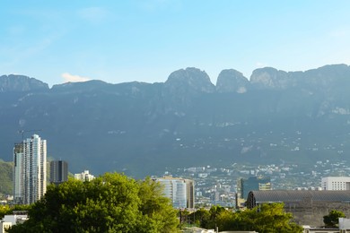 Photo of Picturesque view of mountains and city with skyscrapers