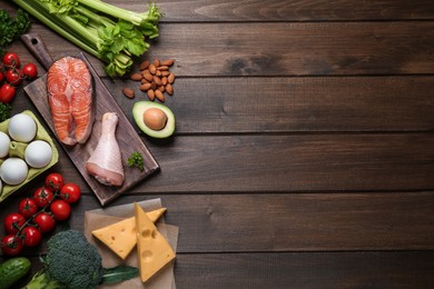 Flat lay composition with keto diet products on wooden table, space for text