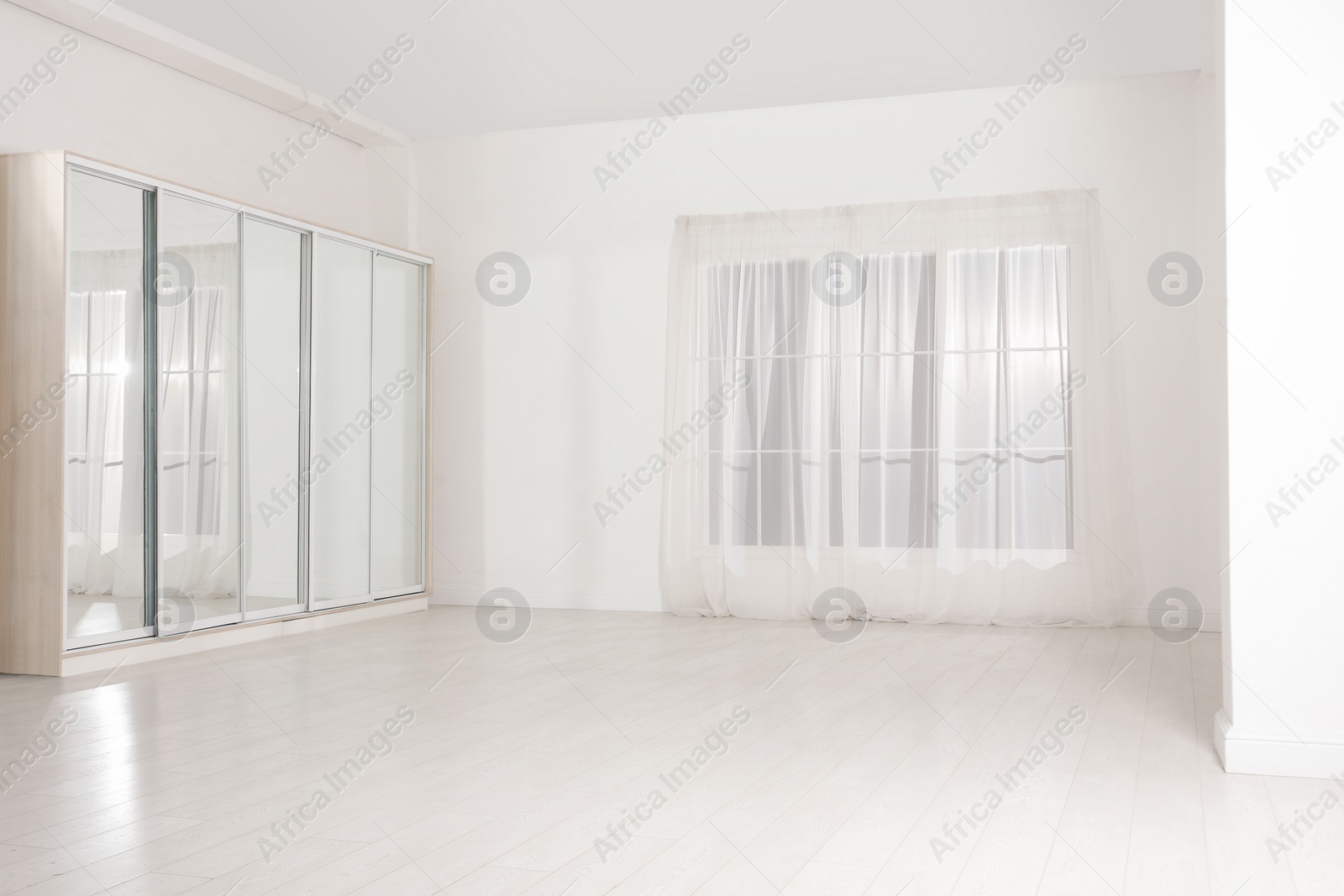 Photo of Empty room with white walls and large window