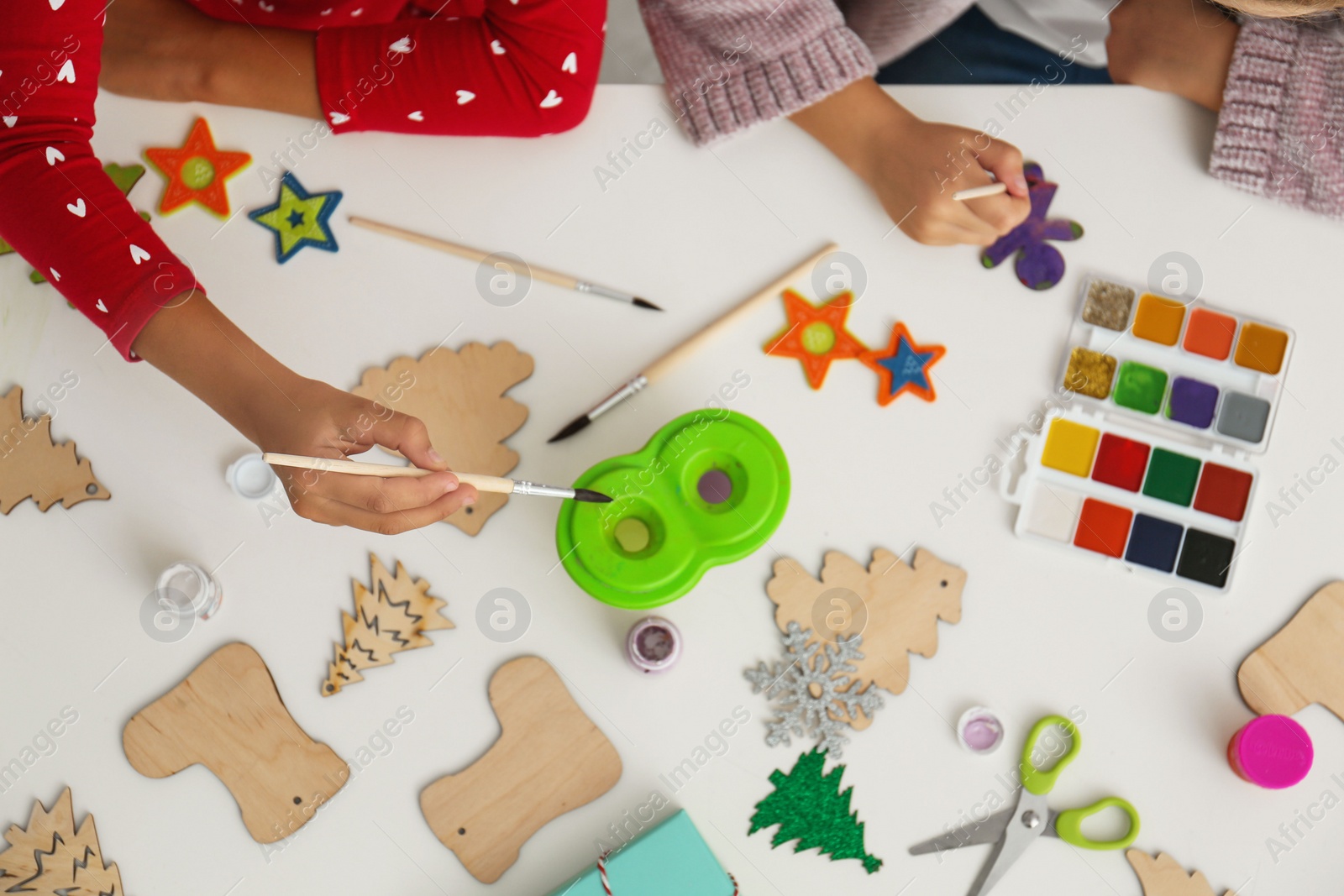 Photo of Children making Christmas crafts at table, top view