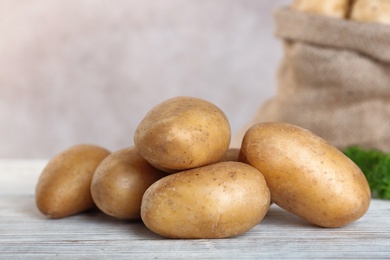 Fresh ripe organic potatoes on wooden table