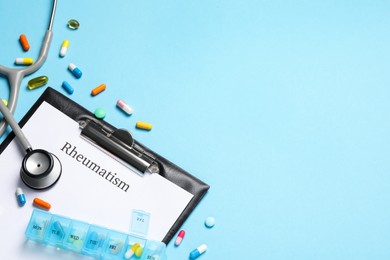 Photo of Clipboard with word Rheumatism, stethoscope and pills on light blue background, flat lay. Space for text