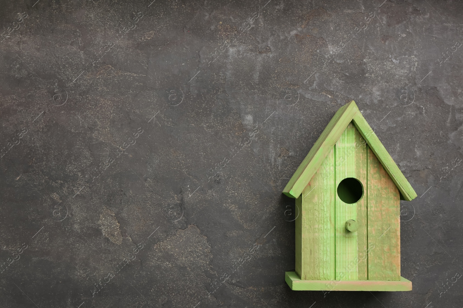 Photo of Beautiful green bird house on grey background, space for text