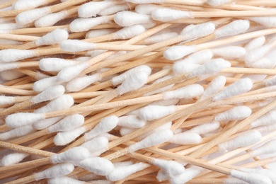 Pile of cotton swabs as background, top view