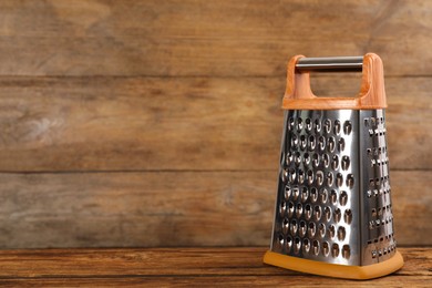 Modern grater on wooden table. Space for text