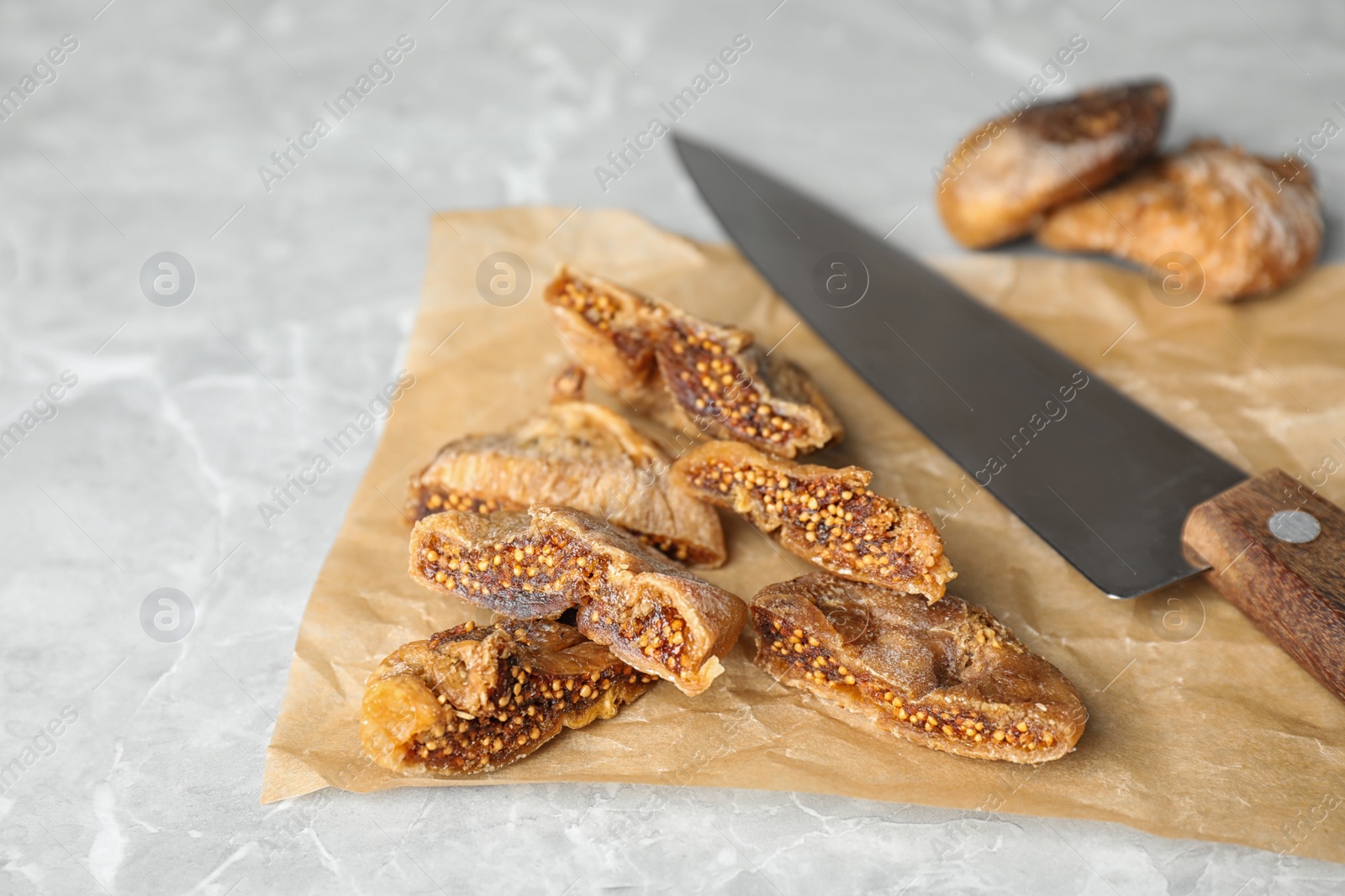 Photo of Tasty cut dried figs on light grey marble table, closeup