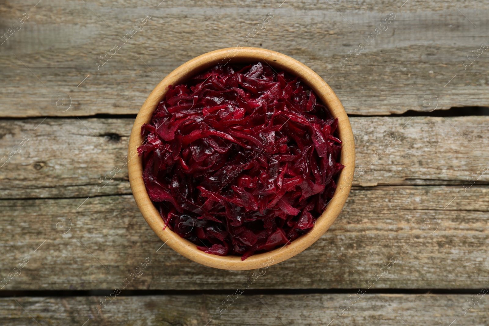 Photo of Tasty red cabbage sauerkraut on wooden table, top view