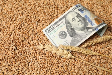 Photo of Dollar banknote and wheat ears on grains, closeup. Agricultural business