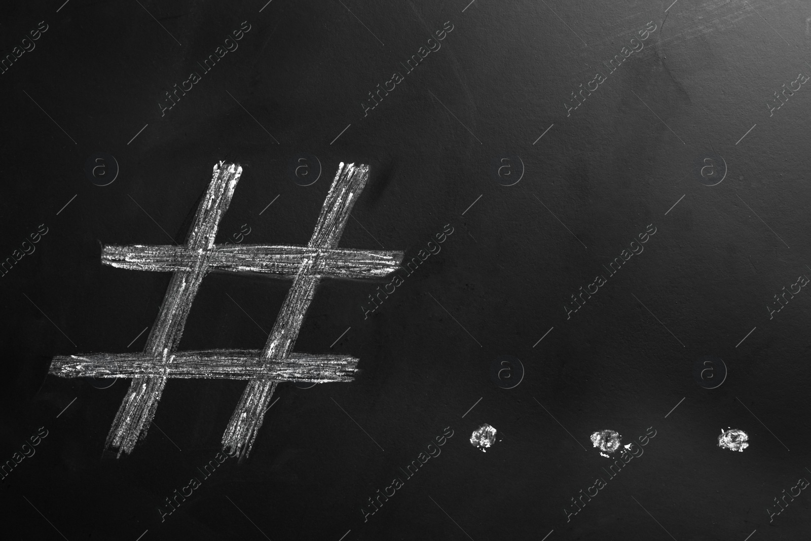 Photo of Hashtag symbol and ellipsis drawn with chalk on blackboard. Space for text