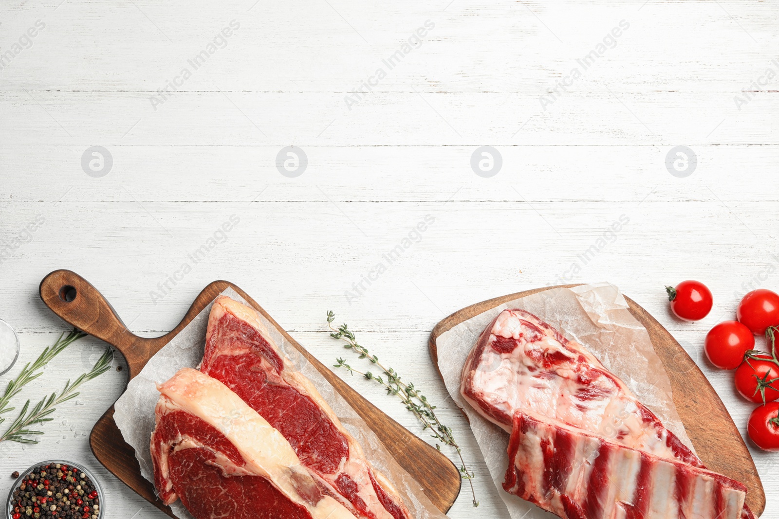 Photo of Flat lay composition with fresh beef meat on white wooden table. Space for text