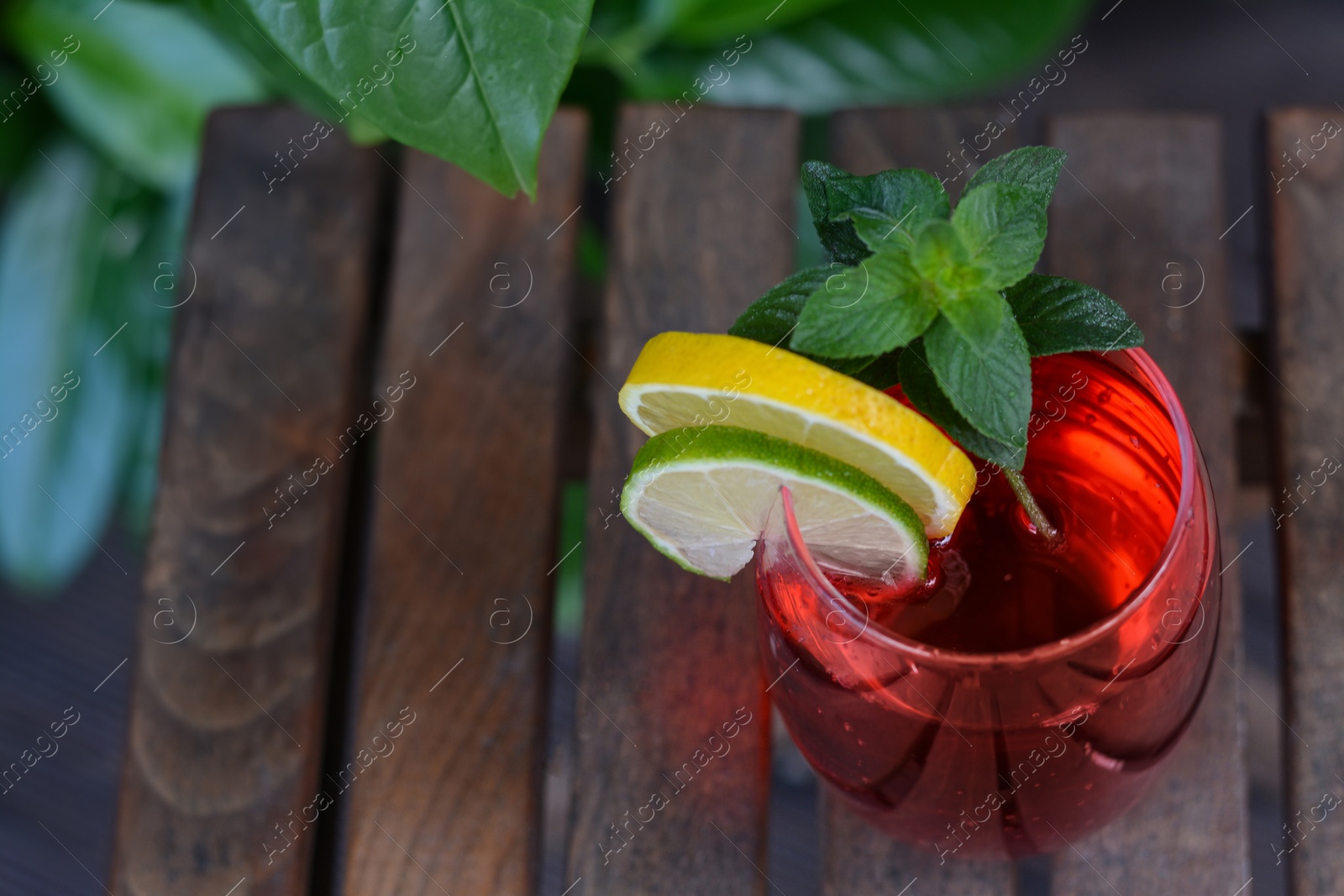 Photo of Closeup view of tasty cocktail on wooden table, space for text. Refreshing drink