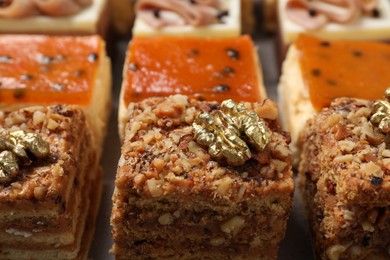 Photo of Pieces of different delicious cakes on table, closeup