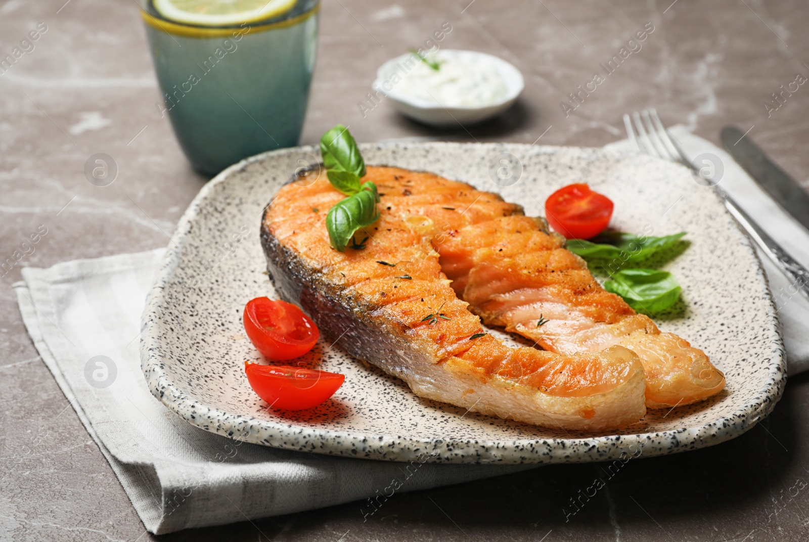 Photo of Plate with tasty salmon steak on grey background