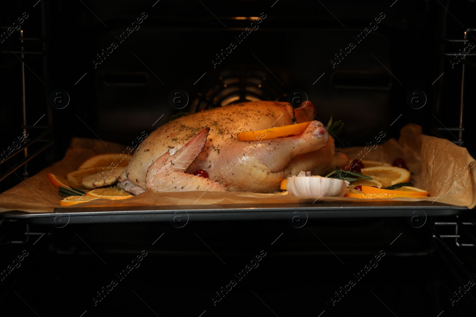 Photo of Chicken with orange slices baking in oven