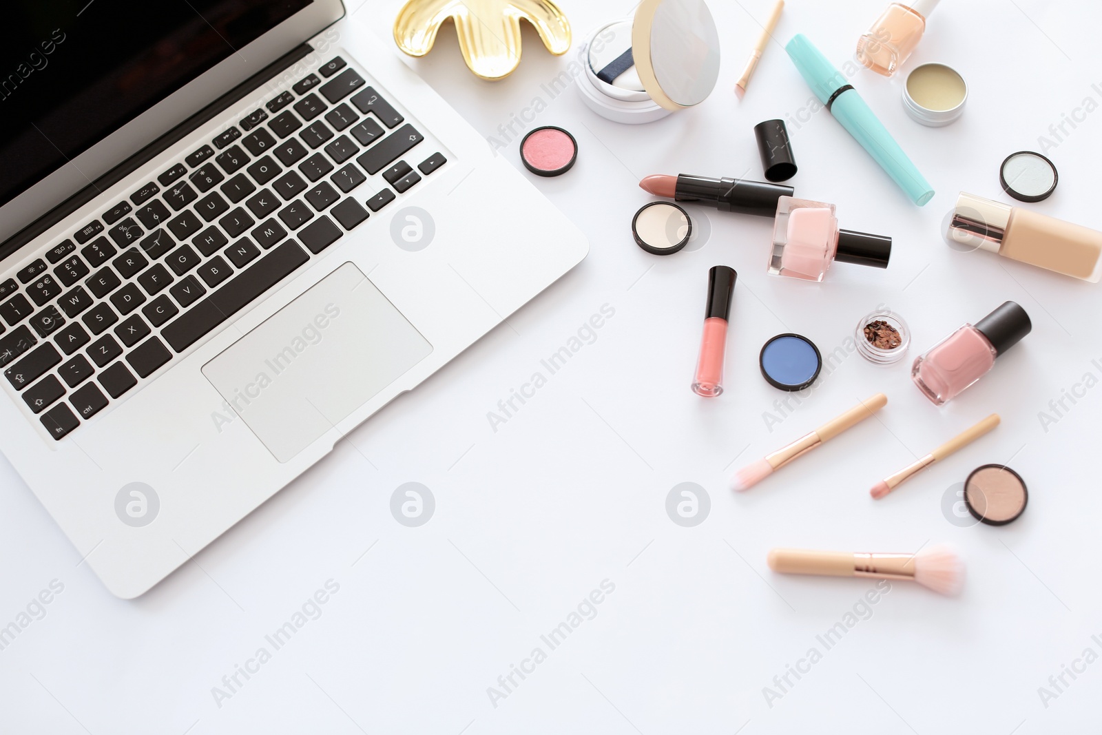 Photo of Flat lay composition with makeup products for woman and laptop on white background
