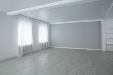 Empty room with large windows and laminated floor