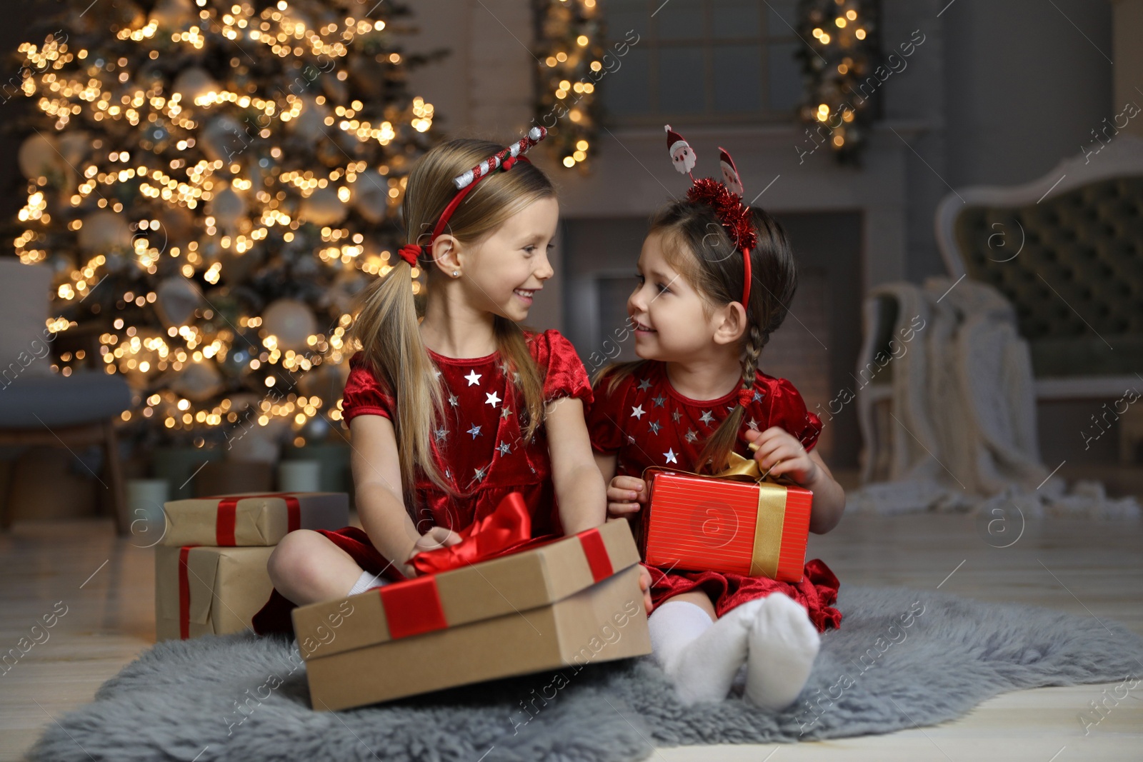 Photo of Cute little children with Christmas gifts in living room