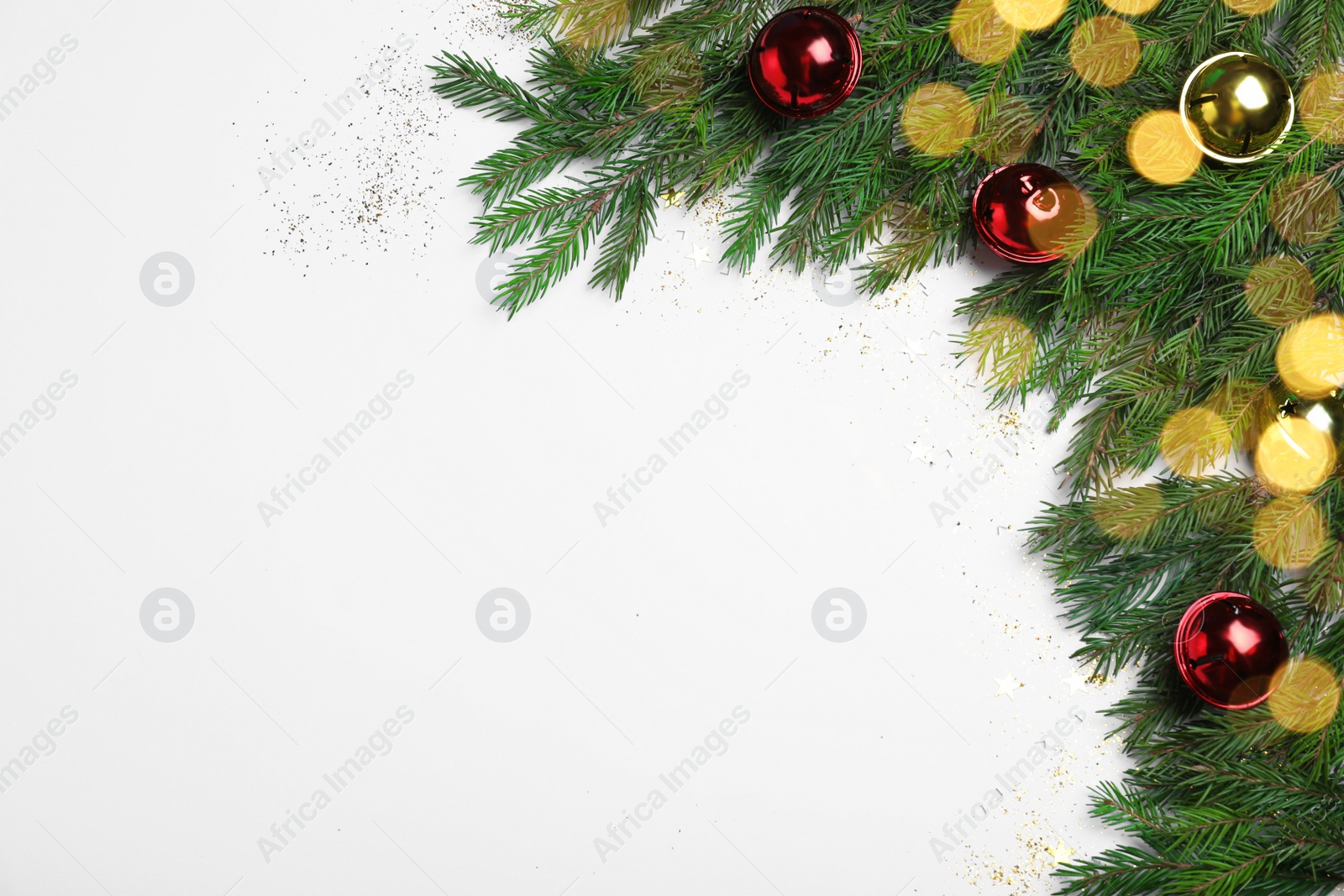 Photo of Flat lay composition with fir tree branches and Christmas decor on white background, space for text. Bokeh effect