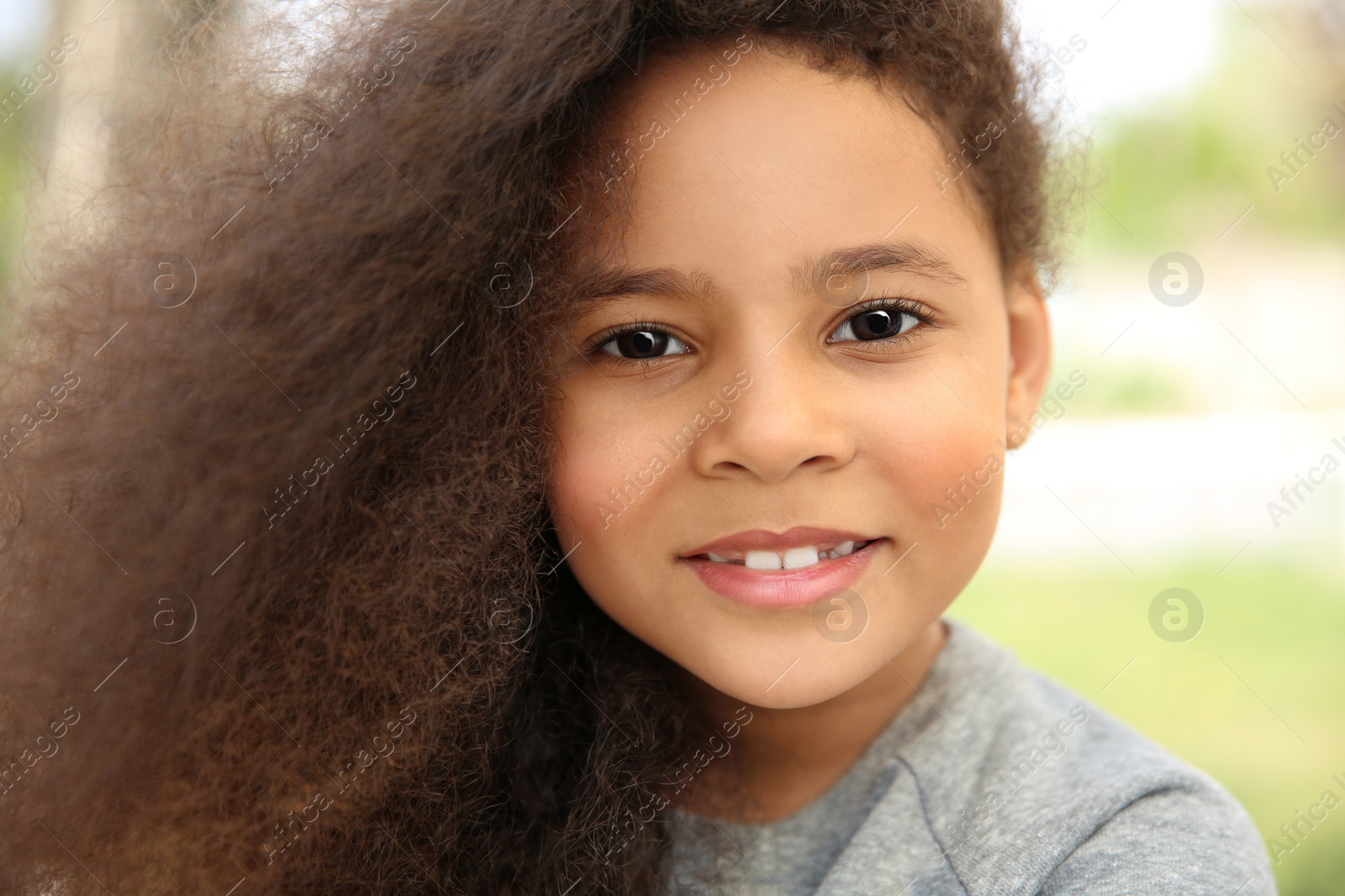 Photo of Cute African-American girl in stylish clothes posing outdoors