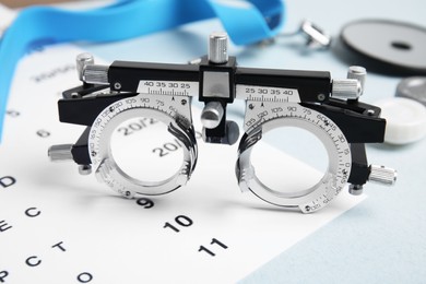 Photo of Trial frame with different ophthalmologist tools on grey background, closeup