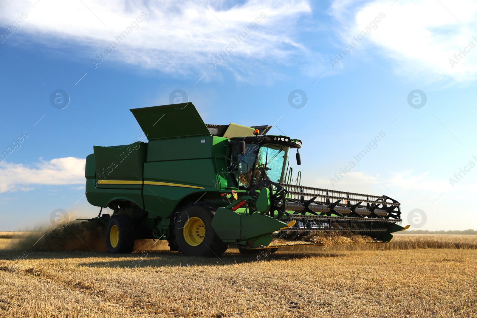 Photo of Modern combine harvester working in agricultural field