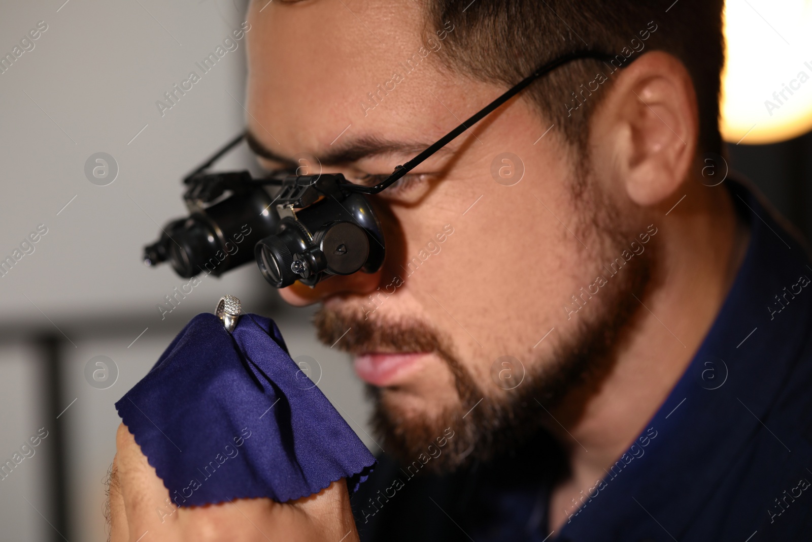 Photo of Jeweler working with ring on blurred background, closeup