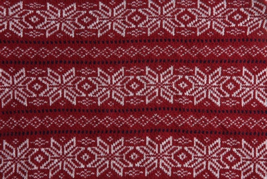 Christmas sweater with pattern as background, top view. Seasonal clothing