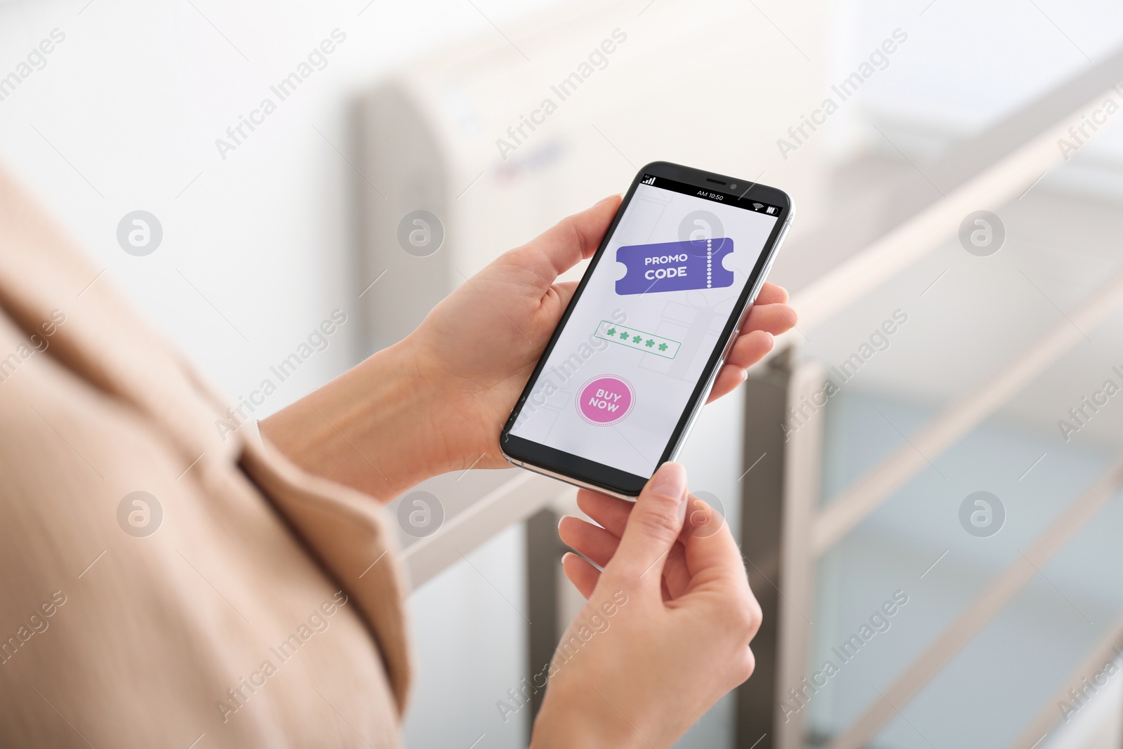 Image of Woman holding smartphone with activated promo code in online shopping app indoors, closeup